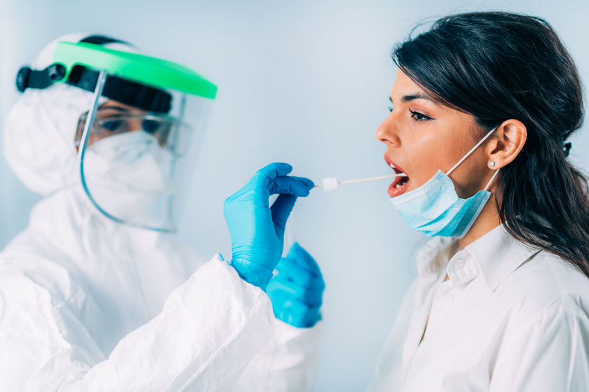 Healthcare worker administering COVID-19 test swab.